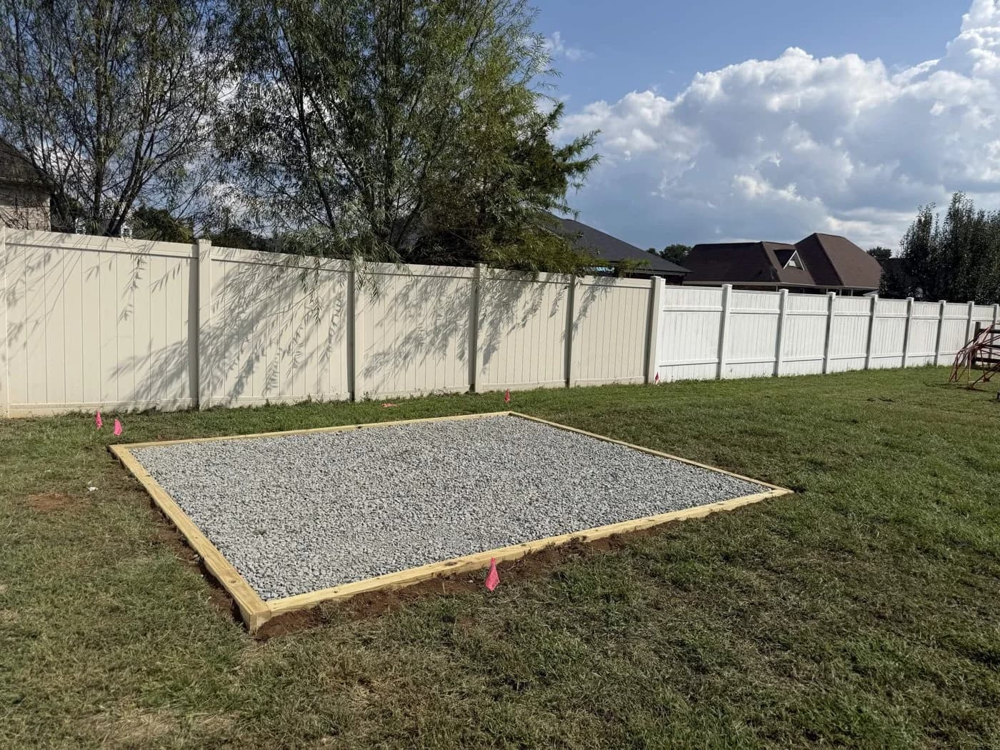 Completed gravel pad with timber edging in a fenced backyard