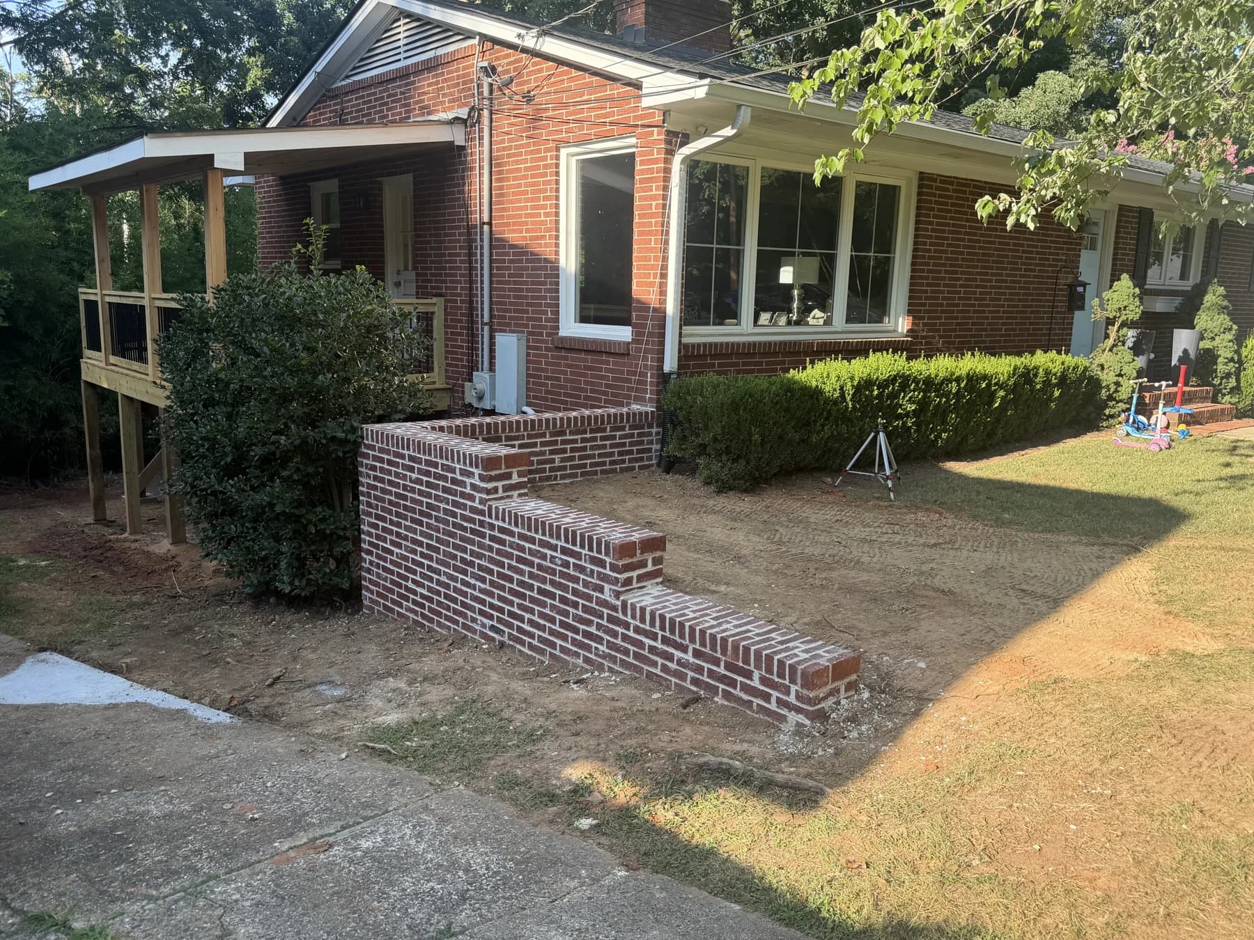 Finished replacement brick retaining wall beside a Charlotte home